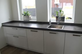 Witte strakke keuken met betonlook aanrecht