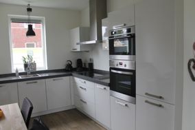 Witte strakke keuken met zwart aanrecht